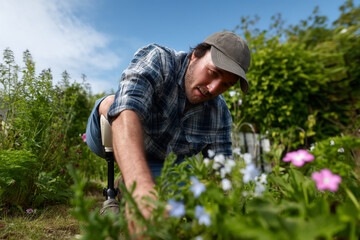 A man with a prosthetic leg gardens.