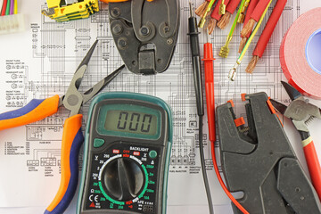 Digital multimeter, wiring tools for assembling an electrical panel. On the electrical diagram during the assembly of the electrical panel. 