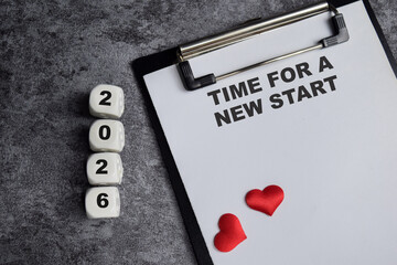 Concept of Time for a new start 2026 write on paperwork isolated on Wooden Table.