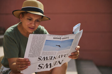 Naklejka premium Woman Reading Newspaper Outdoors on a Sunny Day