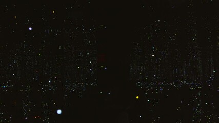This video features a smooth panning shot inside a pitch-black mirrored room filled with thousands of suspended lights, creating the illusion of floating fireflies or a starry night sky. The immersive