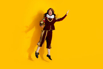 Man Dressed as a Medieval Nobleman Posing Against Yellow Background