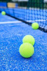 selective focus, paddle tennis balls near the net in a padel court ground level view