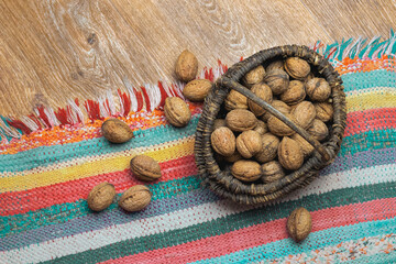 Wicker basket with walnuts on the floor, handmade rug