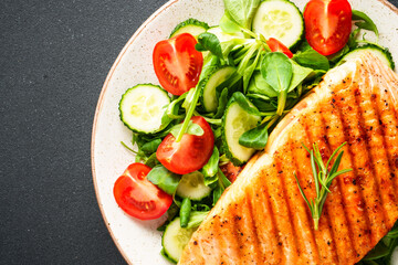 Fish salad. Healthy food, keto diet plate on black background.