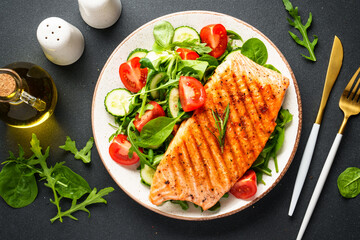 Fish salad. Healthy food, keto diet plate on black background.