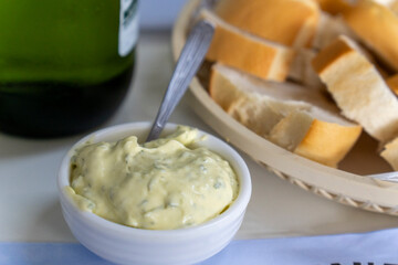 Garlic mayonaisse for spread on bread slices and a bottle of wine on table in Ushuaia Argentina