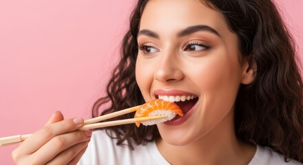Young woman enjoying sushi with chopsticks on vibrant pink background