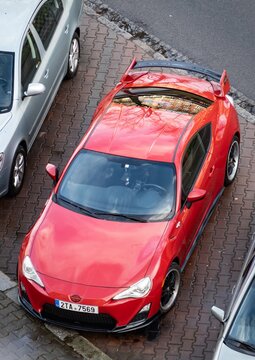 Top front view of red Scion FR-S sports car known as Toyota GT86 or Subaru BRZ, parked on street
