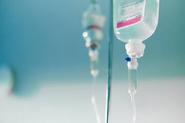 parenteral fluid bags hang from hospital equipment for intravenous delivery of medication and...