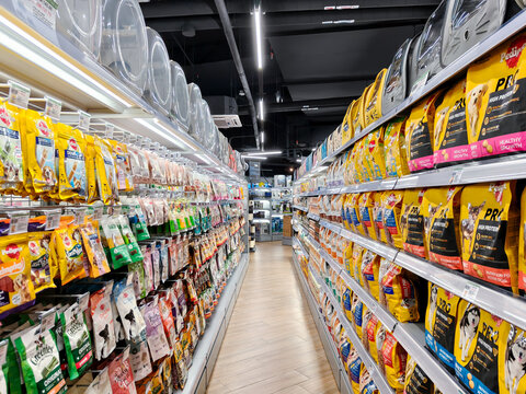 PENANG, MALAYSIA - DEC 26, 2024: Wide-angle view of a well-stocked pet food aisle in a modern supermarket, showcasing a variety of dog food brands
