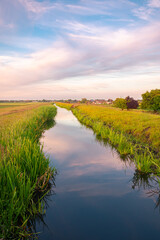 Scenic view of a ditch on a dike in the Dutch polder landscape at the time of sunset