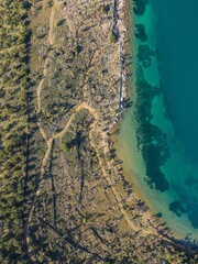 Aerial view of a coastal landscape with clear turquoise waters and lush greenery.