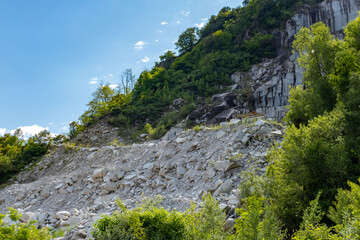 Massive rock walls site Montorfano in active stone mining site, large Granite Quarry, Natural Resources extraction, Stone Industry, essential material for construction