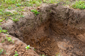 deep excavation site in earth, showcasing preparations for underground utility repairs, silage pit or grave site, groundwork preparation