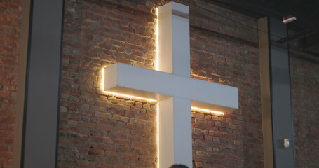 Group of people sitting in front of a cross in a spiritual setting, with a woman in focus looking...