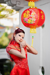 Young woman in red Chinese outfit holding festive lantern for Chinese New Year celebration