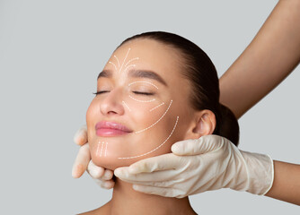 Beauty Treatment. Calm girl receiving face massage from cosmetologist who wearing protective...