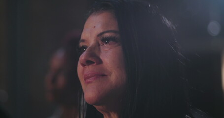 Close-up of woman with tears and emotional expression, deeply moved during prayer at church,...