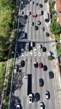 Tr&acirc;nsito congestionado com v&aacute;rios carros e &ocirc;nibus em movimento lento. Movimento urbano cotidiano em vias principais
