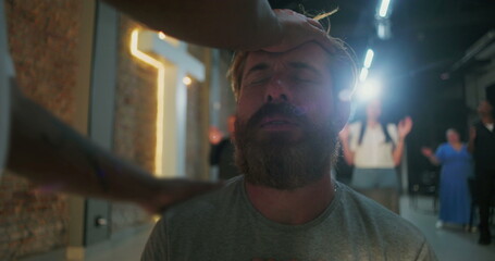 Man receiving prayer support, head touched by hand, emotional moment of faith and spiritual intervention, people praying in background, Christian faith