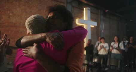 Congregation members embracing during a Christian event, sharing a moment of spiritual connection...