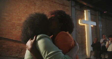Congregation members sharing an emotional embrace during a Christian event, expressing love and spiritual connection