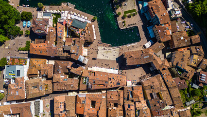 Aerial view of Riva del Garda with Torre Apponale, MAG museum, bike paths, boats and river ferries...