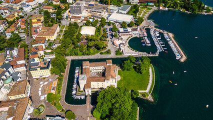 Aerial view of Riva del Garda with Torre Apponale, MAG museum, bike paths, boats and river ferries...