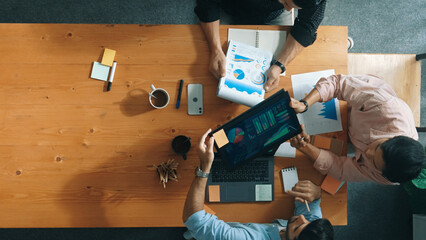 Top view of skilled project manager talking about financial graph to investors while sitting at...