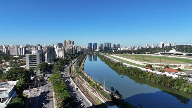 Vis&atilde;o a&eacute;rea da Marginal Pinheiros em S&atilde;o Paulo, com tr&aacute;fego intenso, vias expressas e os trilhos da CPTM ao lado do rio, compondo o cen&aacute;rio urbano da metr&oacute;pole paulista