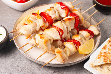Grilled chicken skewers. Satay with side lemon and salad. Kebab with sauces. 