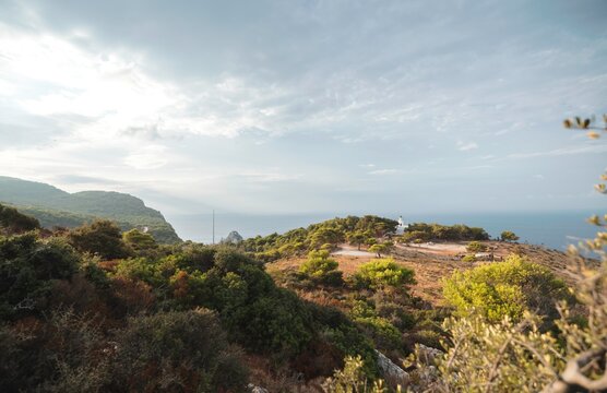 Breathtaking coastal scenery of Zakynthos captured in summer, showcasing lush greenery and dramatic cliffs meeting tranquil waters under a serene sky. Peace and adventure await