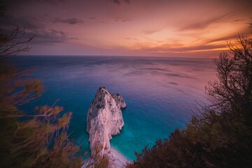 Witness a serene Zakynthos sunset where vibrant colors blend over calm seas