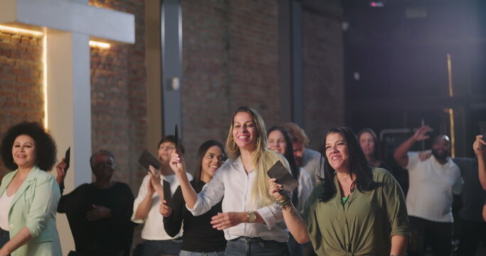 Two women placing offering envelopes into the collection box during church worship, joyful and reverent expressions, diverse community in background participating in spiritual offering
