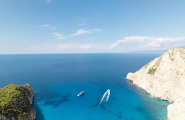 Exploring the stunning coast of Zakynthos in summer showcases deep blue waters and picturesque cliffs, with boats enjoying the sunny weather and tranquil surroundings