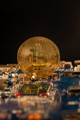 A bitcoin standing on a circuitboard with a black background. The technology is related in the cryptography made with computers.