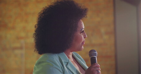 Close-up of a woman speaking into a microphone, addressing audience with passion and authority...