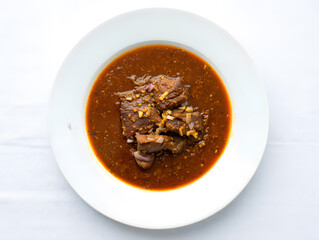 Delicious braised beef stew served in a white bowl on a clean wh