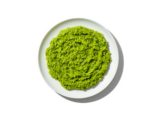 Overhead view of creamy green pea puree served on a white plate