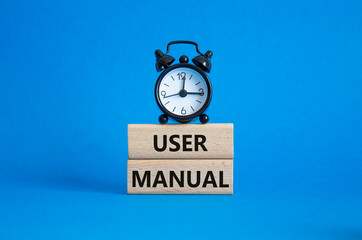 User Manual symbol. Concept words User Manual on wooden blocks. Beautiful blue background with...