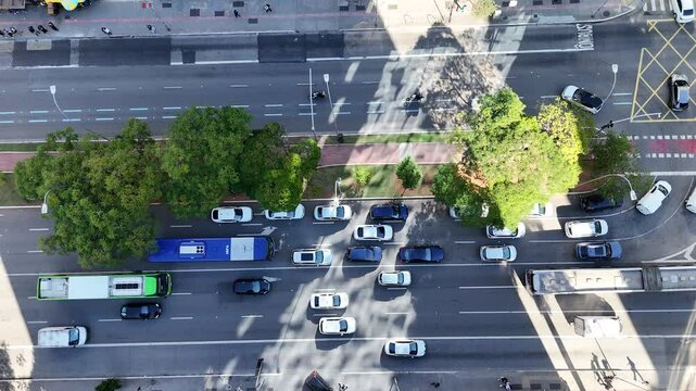 Movimento intenso de carros pelas ruas da cidade com tr&aacute;fego urbano denso captado por drone em vista a&eacute;rea