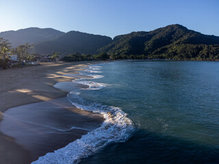 Amazing lighting on orange sand beach and strong waves in coastal village