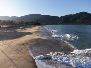 Amazing lighting on orange sand beach and strong waves in coastal village