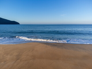 Beautiful orange sand beach and ocean horizon at dawn