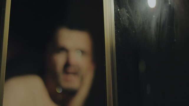 Man in the shower cabin, morning shower, body cleanliness.A man in the shower.Man is under water drops in showers.