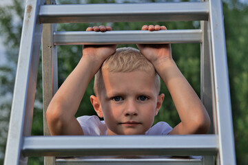 little boy looking through ladder