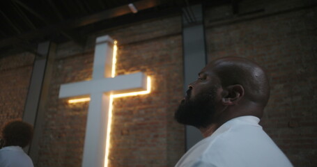 Person in congregation attending church service, looking up with spiritual reflection near...