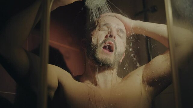 European sexy naked guy washing with lotion gel apply shampoo bottle in dark shower bathroom athletic bare wet man cleaning muscular body liquid soap foam hot water male beauty bath cosmetics.