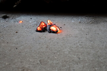 Glowing embers on concrete surface
